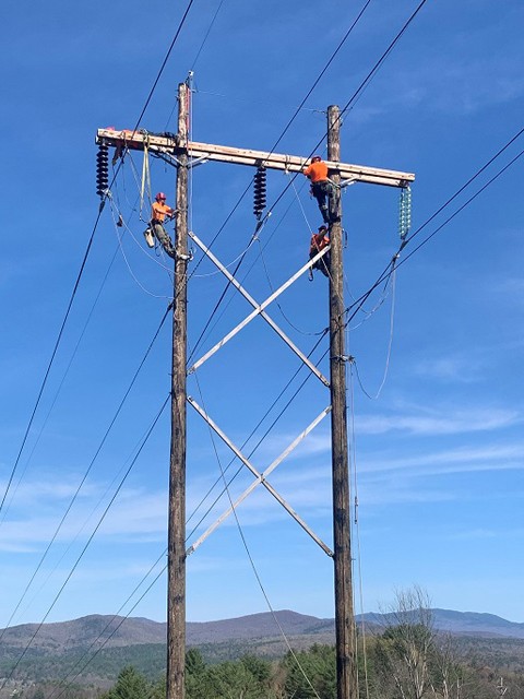 VELCO workers on power line pole